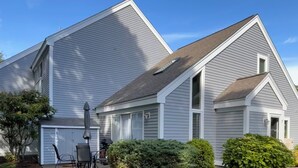 A two-story house with a covered patio and a lawn. - Sunlit townhome at Ocean Edge Resort in Brewster- central A/C, pool privilege's (Brewster)