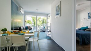 A modern, open-plan living space with a dining area, a sofa, and a bed. - Fenyves by Interhome (Balatonszemes)