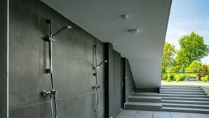 A modern bathroom with grey tiles and a shower area. - Fenyves by Interhome (Balatonszemes)
