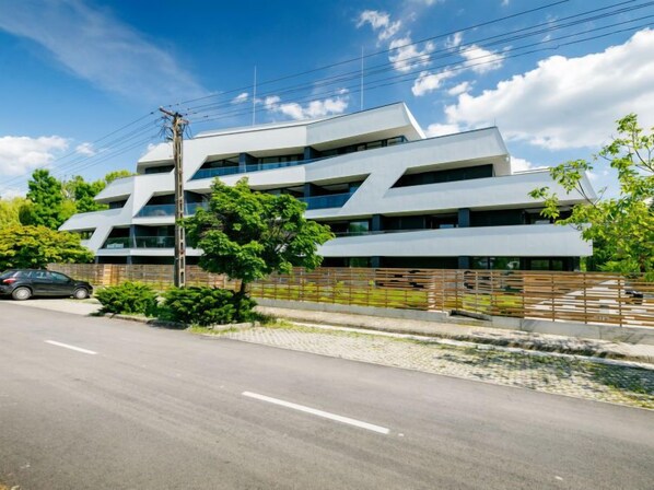 A modern multi-story building with a flat roof and large windows.
