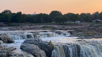 A waterfall with multiple cascades surrounded by rocky terrain and trees.
