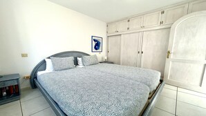 A bedroom with a bed, a wardrobe, and a door.