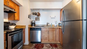 A modern kitchen with stainless steel appliances, wooden cabinets, and a central island.