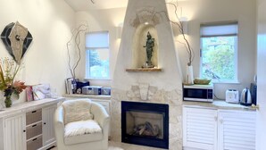 A cozy living room with a stone fireplace, a white sofa, and a decorative statue. - Serene Montclair Getaway (Oakland)