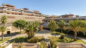 Un hôtel à plusieurs étages doté d’une cour intérieure, de palmiers et d’un terrain de jeux.