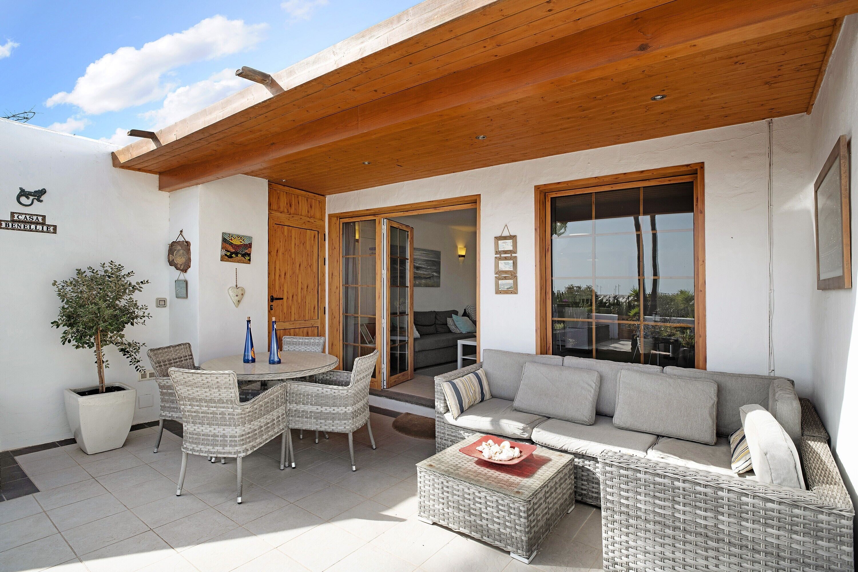 A patio area with wicker furniture, a dining table, and a sofa.