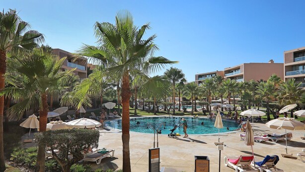 A pool area with lounge chairs, umbrellas, and palm trees. - Salgados 4Seasons Apartment with Pool, A/C, Wi-Fi, Garden & Balcony (Albufeira)