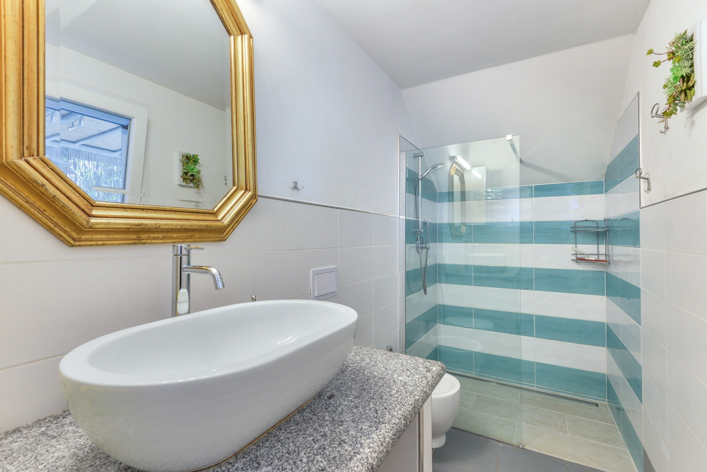 Ein Badezimmer mit freistehender Badewanne, einem großen Spiegel und einer Duschkabine aus Glas.