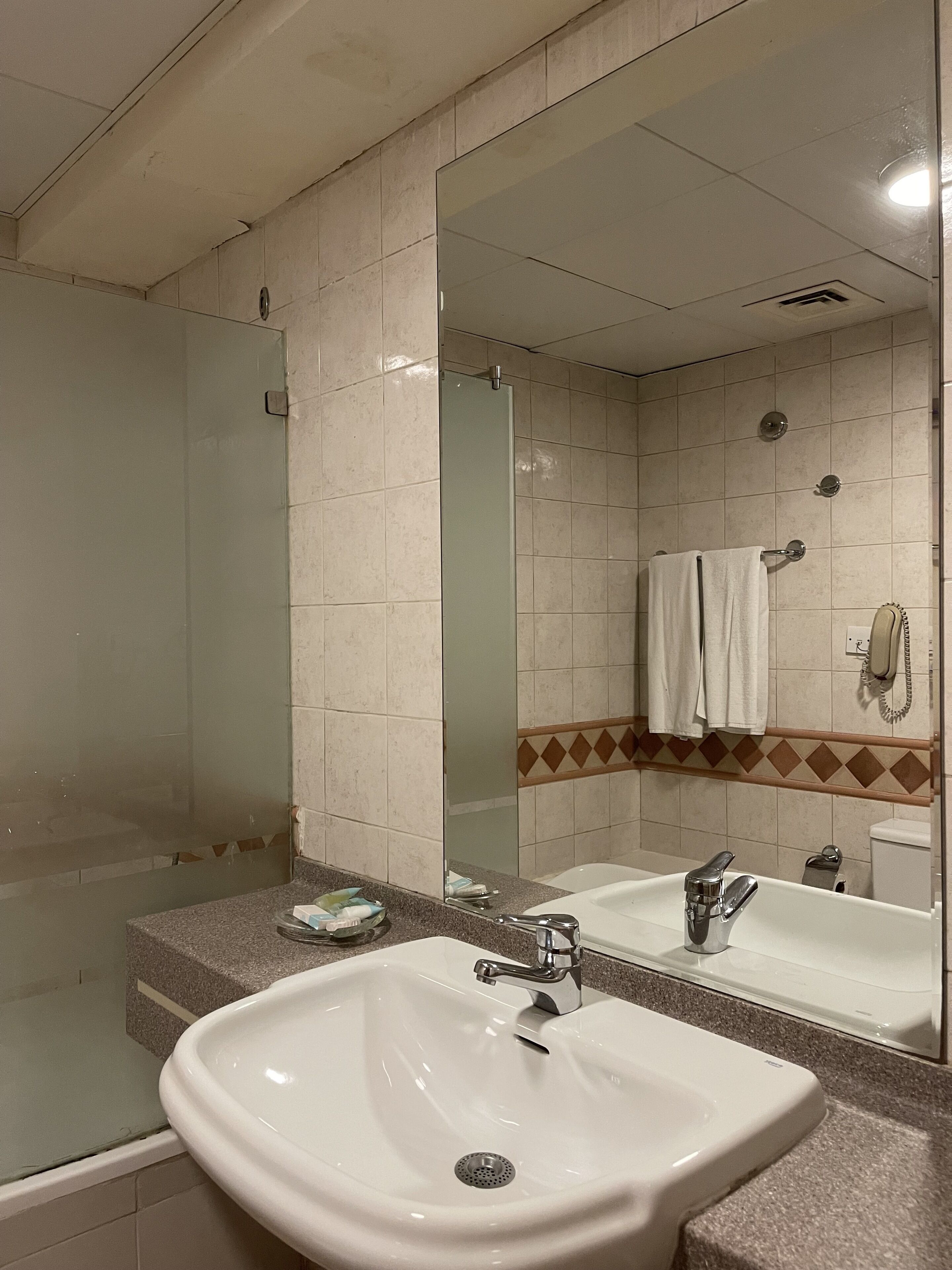 Un baño con lavabo, espejo y ducha.