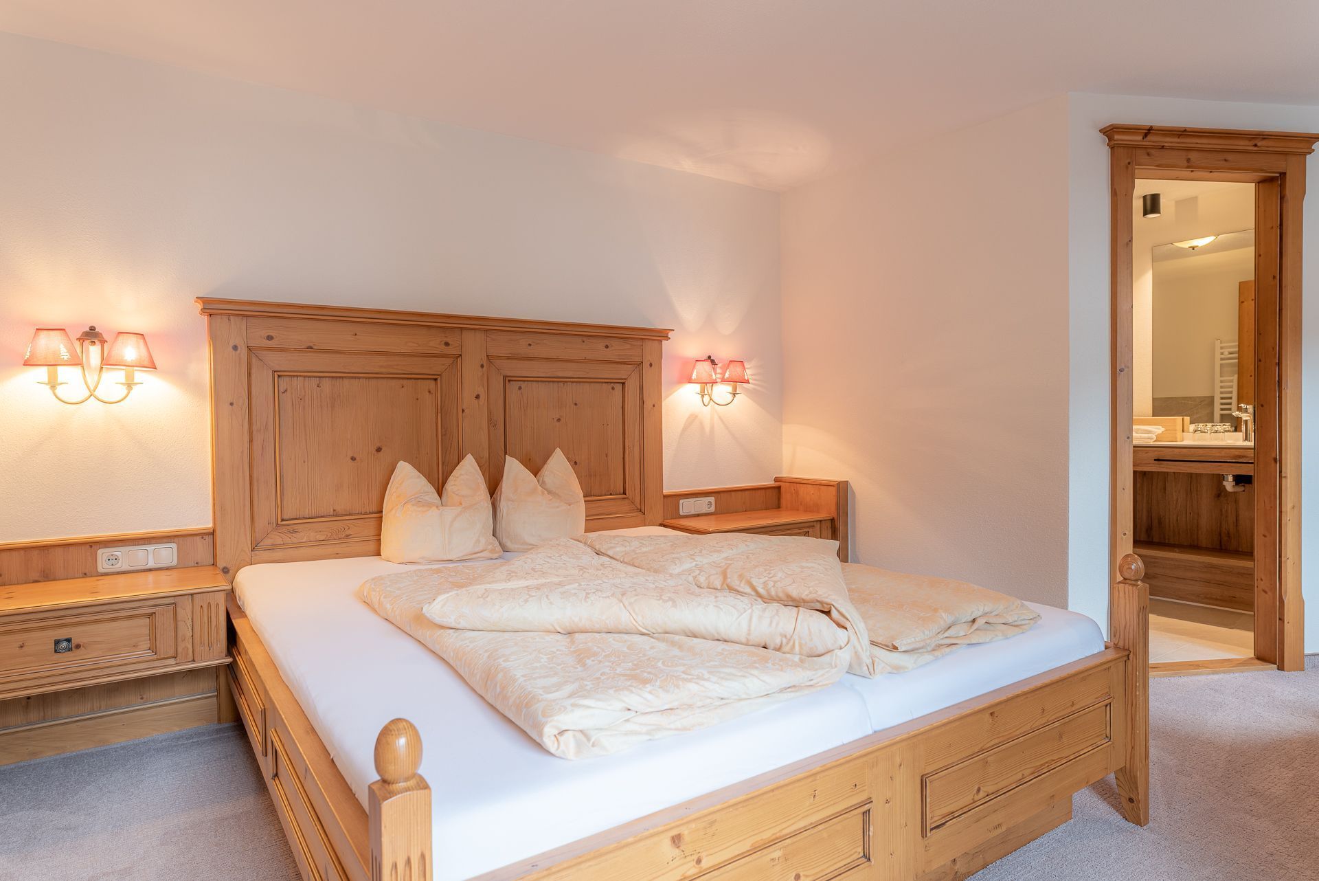 Une chambre à coucher avec un lit en bois, des tables de chevet et des lampes fixées au mur.