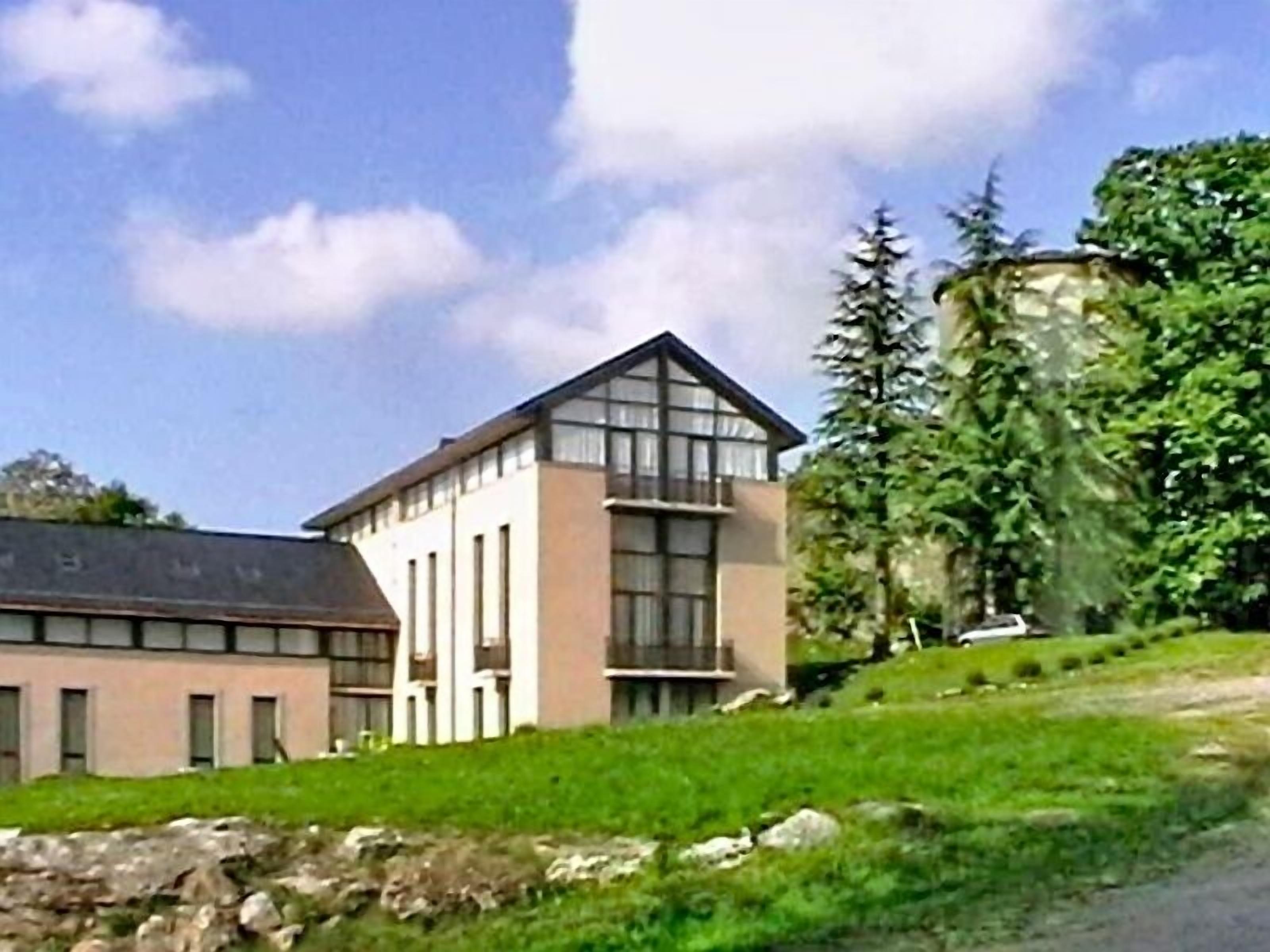A modern building with a flat roof, large windows, and a sloped side.
