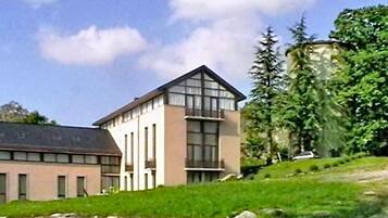 A modern building with a flat roof, large windows, and a sloped side.