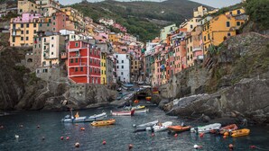 Un village côtier aux bâtiments colorés, où les bateaux sont amarrés le long du rivage.