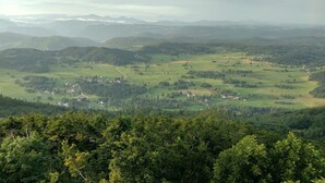 A panoramic view of a mountainous landscape with a valley, roads, and scattered buildings. - Paradise for hikers. Family friendly. (Crni Vrh nad Idrijo)