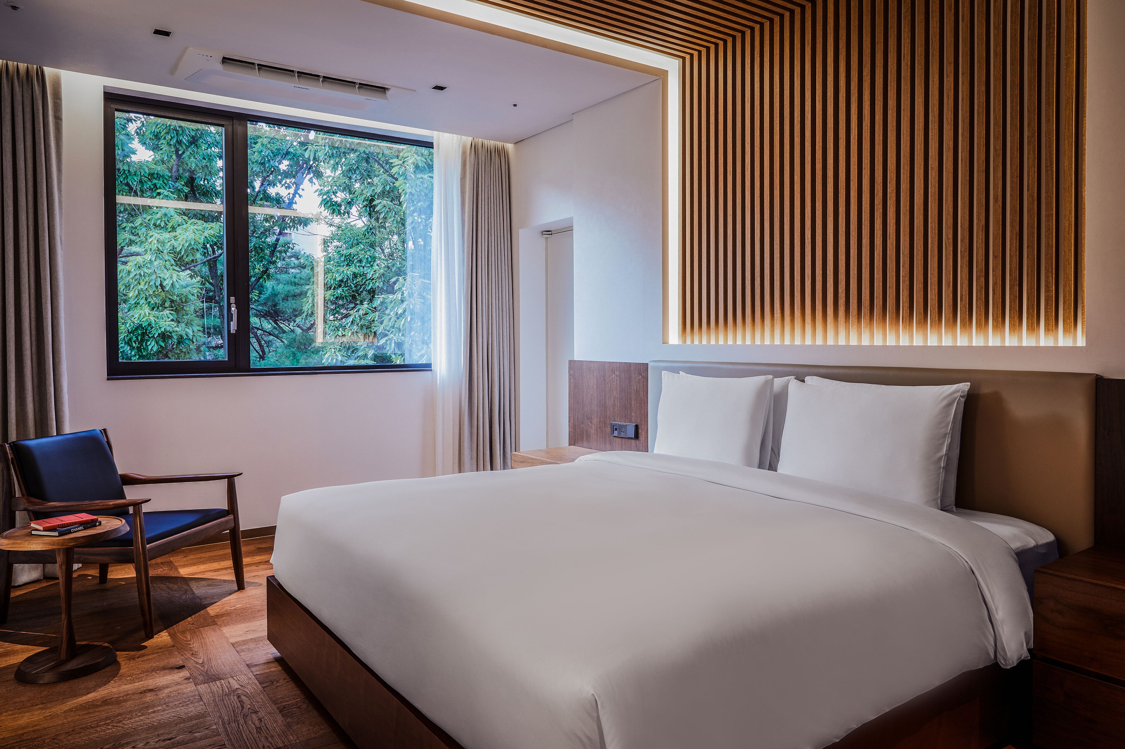 Una habitación de hotel moderna con una cama grande, un escritorio y una silla.