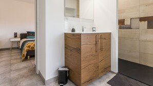 A modern bathroom with a wooden vanity, a mirror, and a sink.