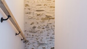 A corner of a room with a textured wall and a wooden beam.
