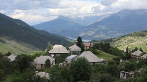 A village with traditional houses surrounded by lush greenery and mountains.