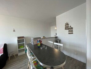 Enjoy meals and snacks in this kitchen with a central island dining area, featuring a refrigerator, coffee maker, and toaster.