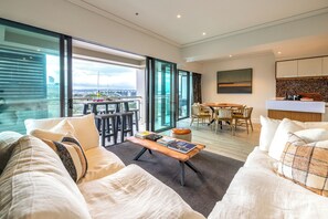 Relax and socialize in this spacious living area with a sofa, dining table, and kitchenette.