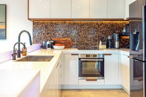 Enjoy cooking in this well-equipped kitchen with a stainless steel sink, oven, and large refrigerator.