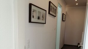 A hallway with wooden flooring and white walls, featuring two framed pictures on the wall. - Vacation apartment/holiday home for up to 5 people (children under 6 free of charge) (Clausthal-Zellerfeld)