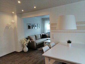 Relax in this inviting living area with a dining table, sofa, and potted plant.