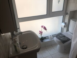 A bathroom with a toilet, sink, and a window with a flower. - Casa Fiore - 2 Bed House 10 Mins Walk to Centre (Rhodes)