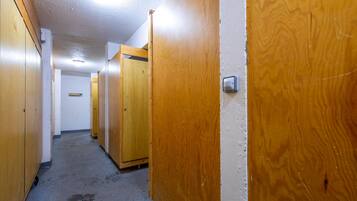 A hallway with wooden doors, a visible hand dryer, and a sign on the wall.