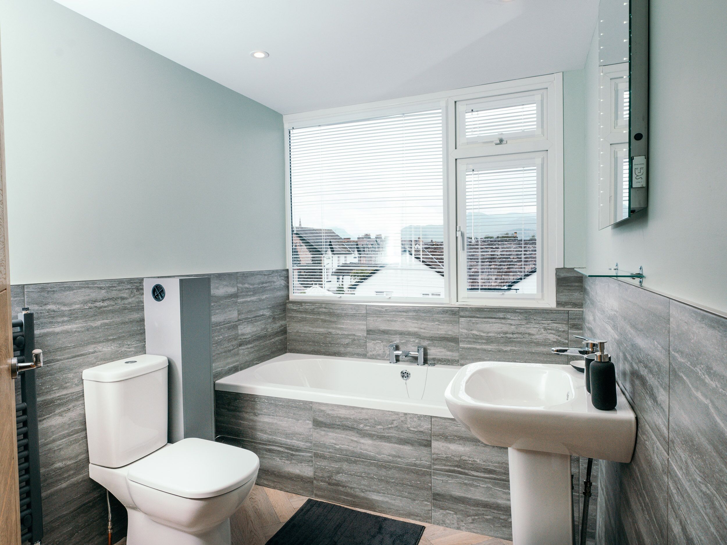 Une salle de bain moderne équipée de toilettes, d’une baignoire et d’un lavabo.