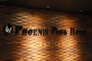 Pared de madera con el texto 'PHOENIX PARK HOTEL' y un logotipo estilizado de un fénix.
