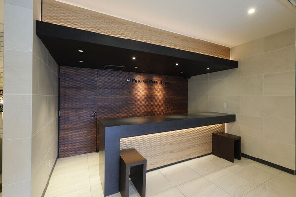 A reception desk with a wooden panel backdrop and a dark counter.