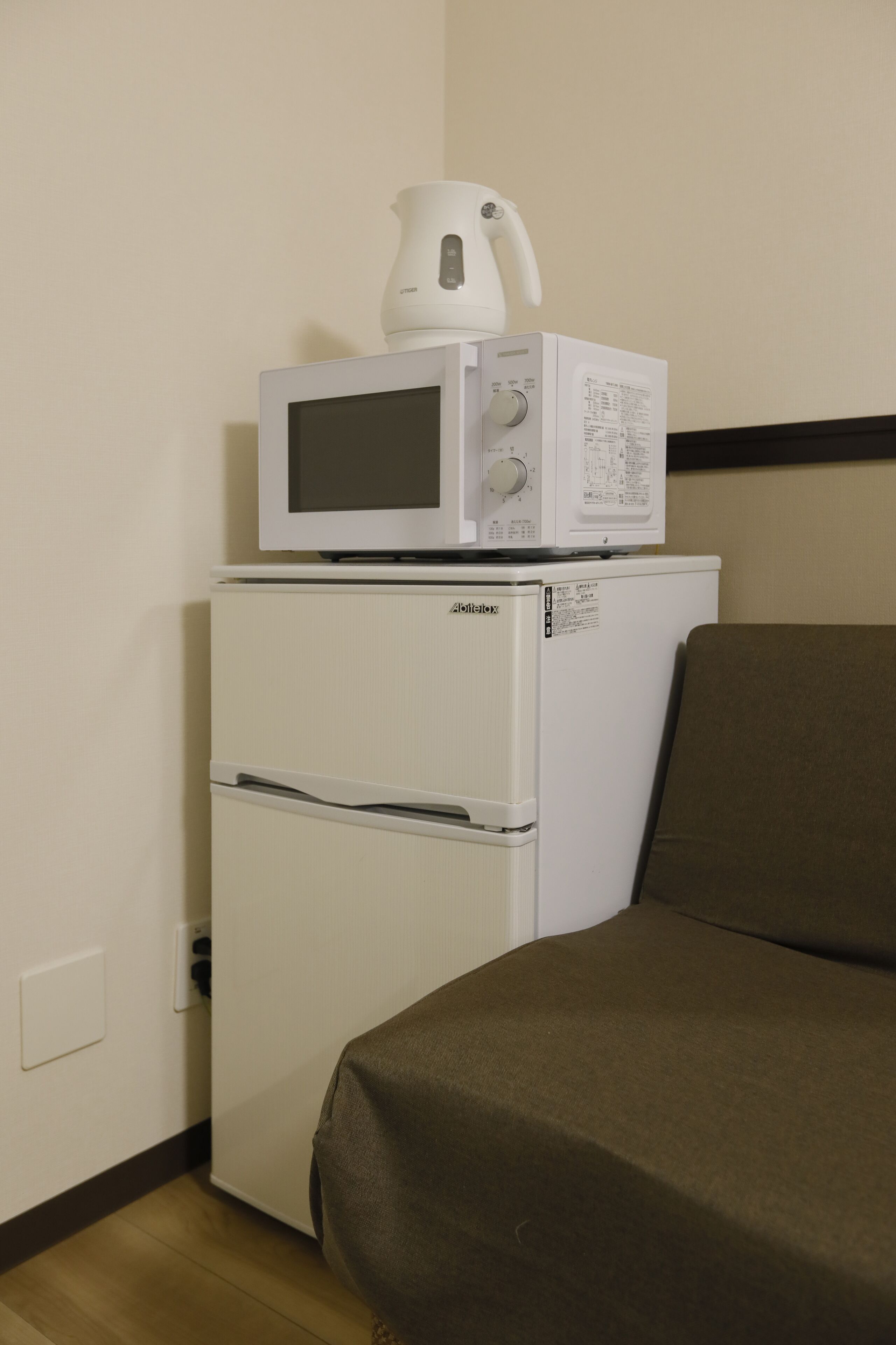 A compact kitchenette with a microwave and a small refrigerator.