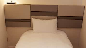 A hotel room with a bed, a nightstand, and three wall-mounted paintings.