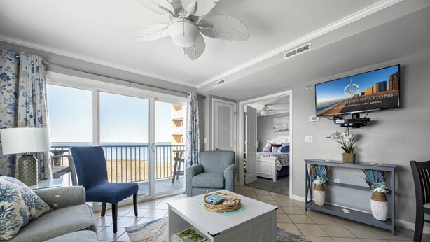 Un salon spacieux avec balcon, une télévision et un coin salon confortable.