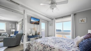Une chambre à coucher avec un lit, un bureau, une chaise et une grande fenêtre.