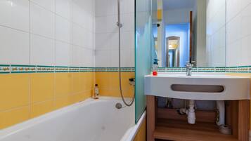 A bathroom with a bathtub, a sink, and a shower.