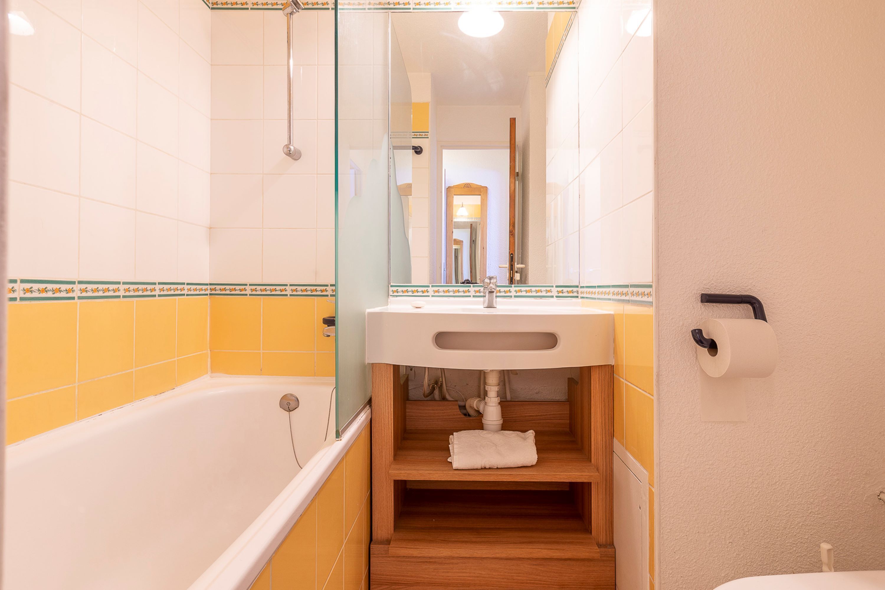 Une salle de bain avec une baignoire, un lavabo et un miroir.