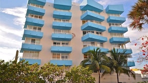 A multi-story hotel with blue balconies and white railings.