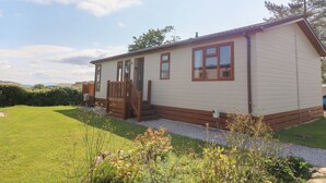 Une maison mobile de plain-pied avec un porche à l’avant et une petite terrasse.