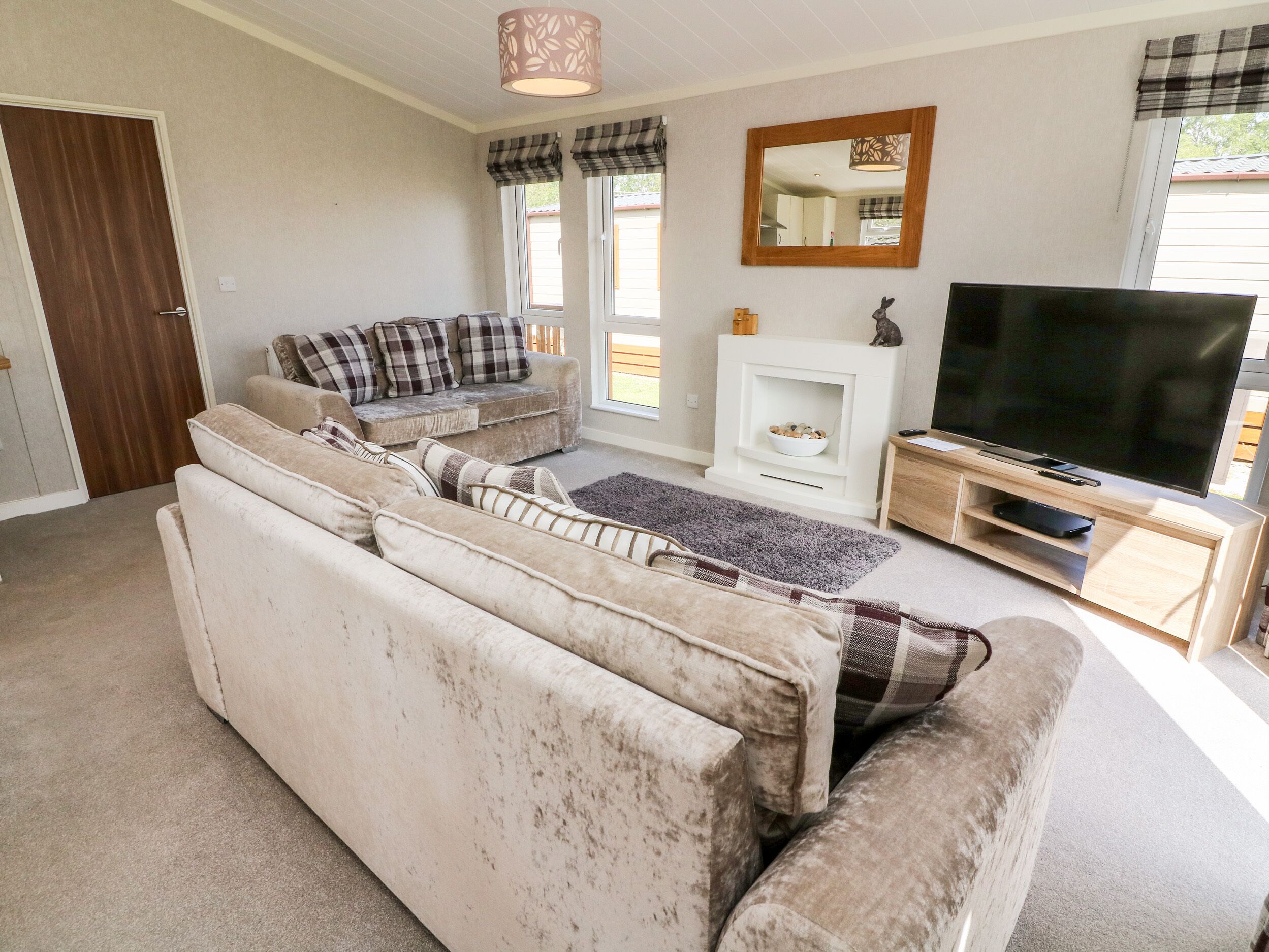 A living room with a large sofa, a television, and a fireplace.