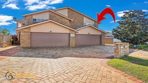 A two-story house with a garage, brick driveway, and a landscaped front yard. - Moy at Nelson Bay - 2/30 Thurlow Avenue (Nelson Bay)