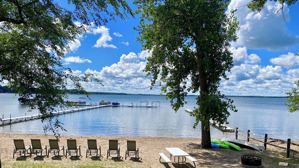 A lakeside picnic area with chairs, a table, and a canoe. - Maryview Beach House, Maryview Beach House (La Grand Township)