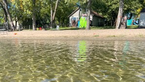 A clear lake with reflections, surrounded by trees and a house with a deck. - Maryview Beach House, Maryview Beach House (La Grand Township)
