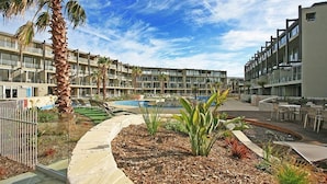 A resort with a pool, palm trees, and a landscaped garden. - Resort 2 Bedroom 224/226 (Torquay)