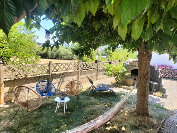 A garden area with outdoor seating, a hammock, and a stone fireplace. - Family house with sea view in Assérac (Assérac)
