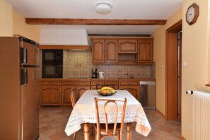 A compact kitchen with wooden cabinets, a refrigerator, a microwave, and a coffee maker. - Gîtes du Couvent, "Oriel"—a beautiful apartment in the historic center of Kaysersberg (Kaysersberg)