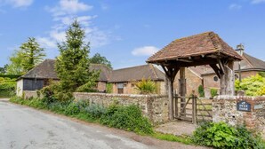 A rural farmstead with stone walls, a wooden gate, and a sign reading "DYKE FARM".