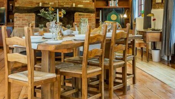 A dining area with wooden furniture and a brick wall backdrop.