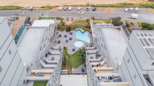 A rooftop pool area with a view of the beach and ocean. - Seaside Apartment @ Perna Perna Umdloti (eMdloti)